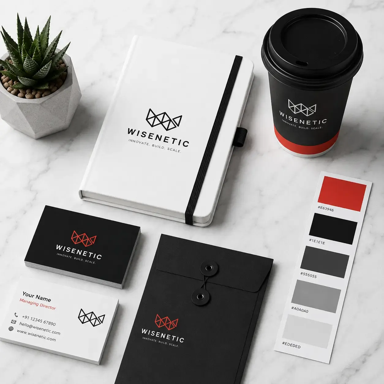 White notebook, black coffee cup, business cards, and color palette displaying brand identity.